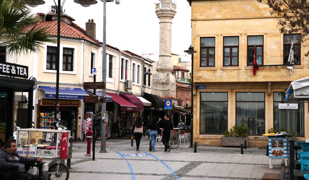 The old city centre of Çanakkale in Türkiye. There are shops and a street vendor.